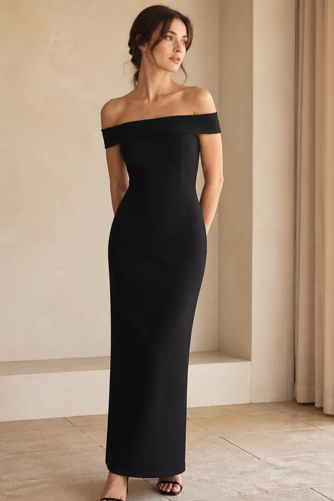 A black off-shoulder crepe dress with tidy waist seams and a fitted bodice; skirt is column-like and ends at the ankle.